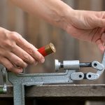 reloading cartridge by shotgun shell reloader, closeup Personal Ammo Factory with Reloading Supplies